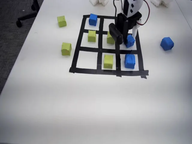 The scene camera view of the tic-tac-toe board with green and blue blocks during a teleoperated demonstration